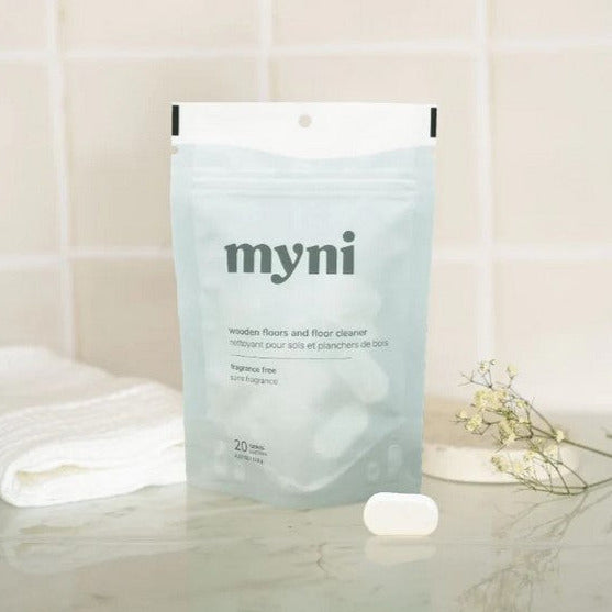 Myni wooden floor cleaner tablet in a clear plastic container with label, designed for use on hardwood and tile floors