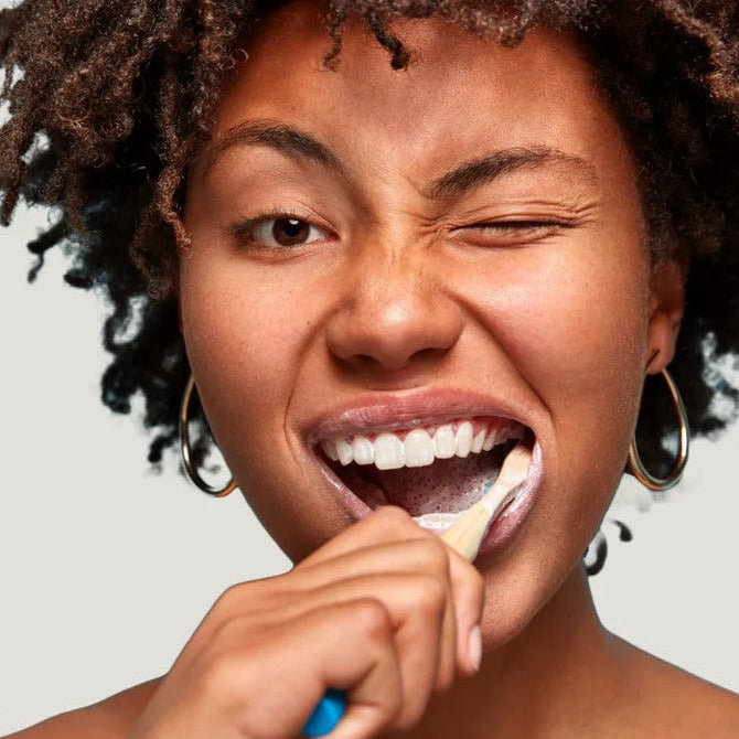 Close-up of the Nelson Naturals Vanilla Orange Toothpaste in a jar’s textured orange-tinted lid and clear glass container