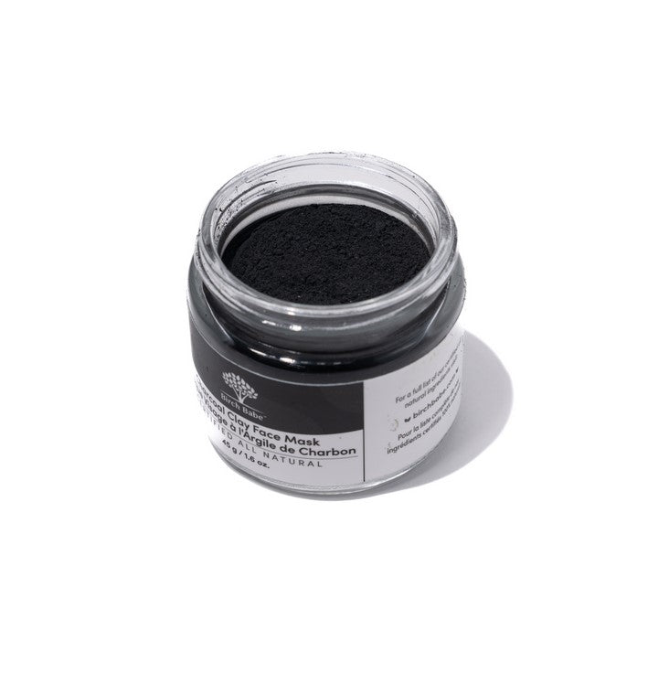 Close-up of charcoal and clay textured surface on face mask container, highlighting natural ingredient detail and matte