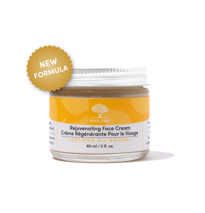 Close-up of Rejuvenating Face Cream jar's textured lid with fresh botanical ingredients displayed around it, highlighting