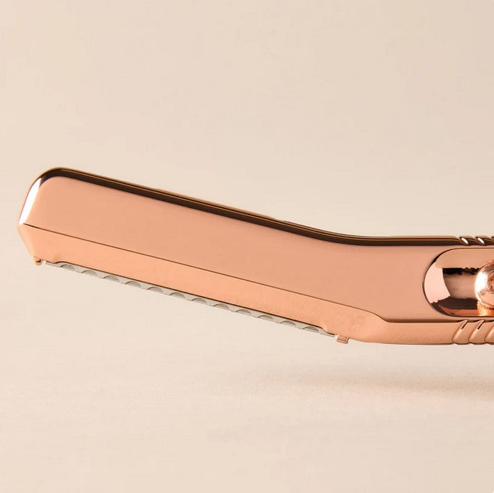 Close-up of the Rose Gold razor blade with textured handle grip and precise edge detail from a side angle.