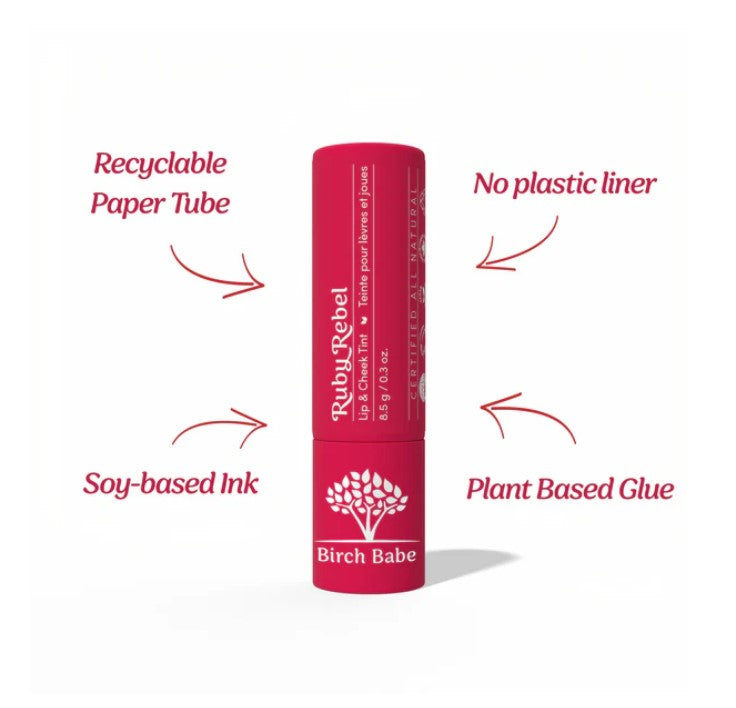 Close-up of Ruby Rebel Lip & Cheek Tint tube displaying product name and matte finish label detail in bright natural light