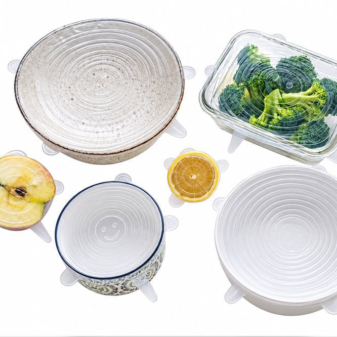 Set of six reusable silicone stretch food covers on bowls, containers and cut produce.