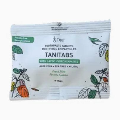 Close-up of TANITABS Fresh Mint Toothpaste Tablets inside clear glass jar showing textured mint-flavored tablets and