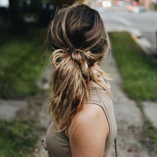 Close-up of biodegradable hair ties stacked, highlighting their soft, flexible texture and eco-friendly material in natural