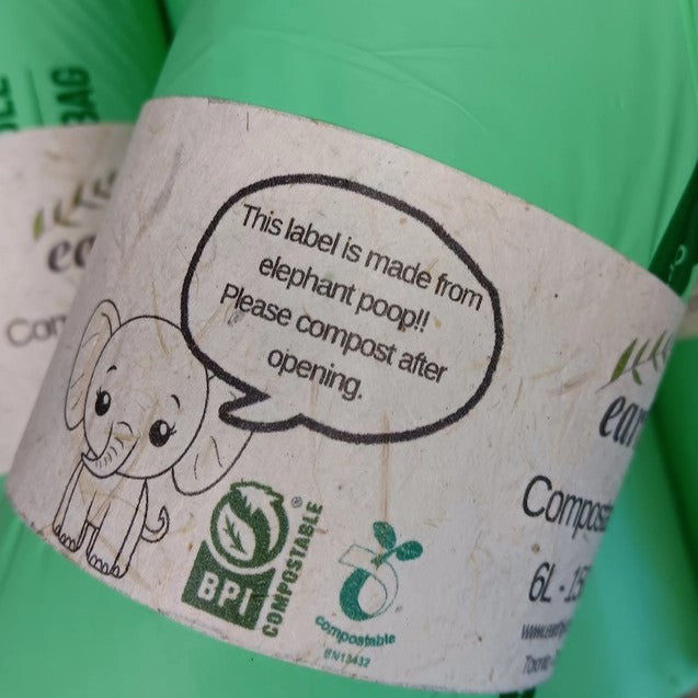 Close-up of the Earthly compostable garbage bag label highlighting eco-friendly material and 60L capacity in a home setting