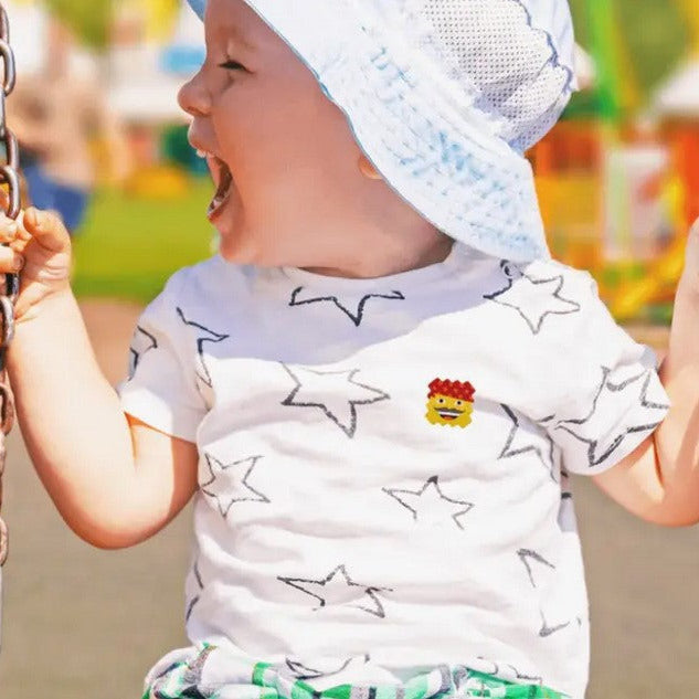 Close-up of NATPAT AllergyPatch sticker's transparent film with textured surface and colorful backing card in background.