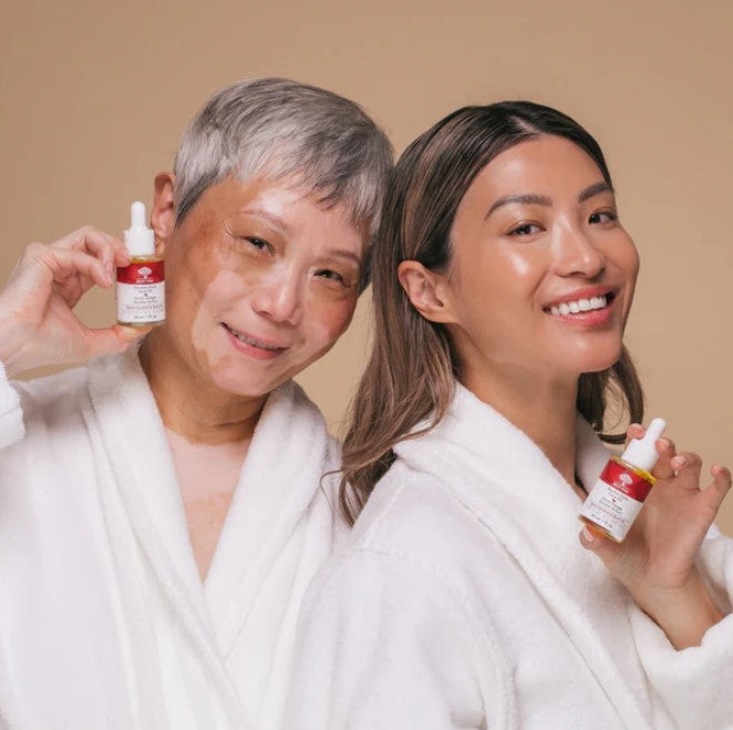 Close-up of double duty face oil dropper cap highlighting sleek black design and gold accents against clear packaging.