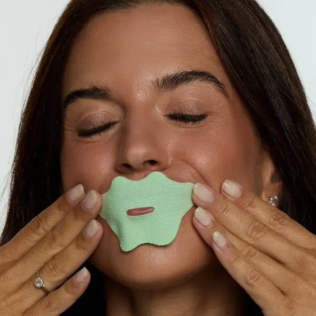 Close-up of minty mouth tape strip highlighting smooth, transparent texture and subtle adhesive edges on a white background