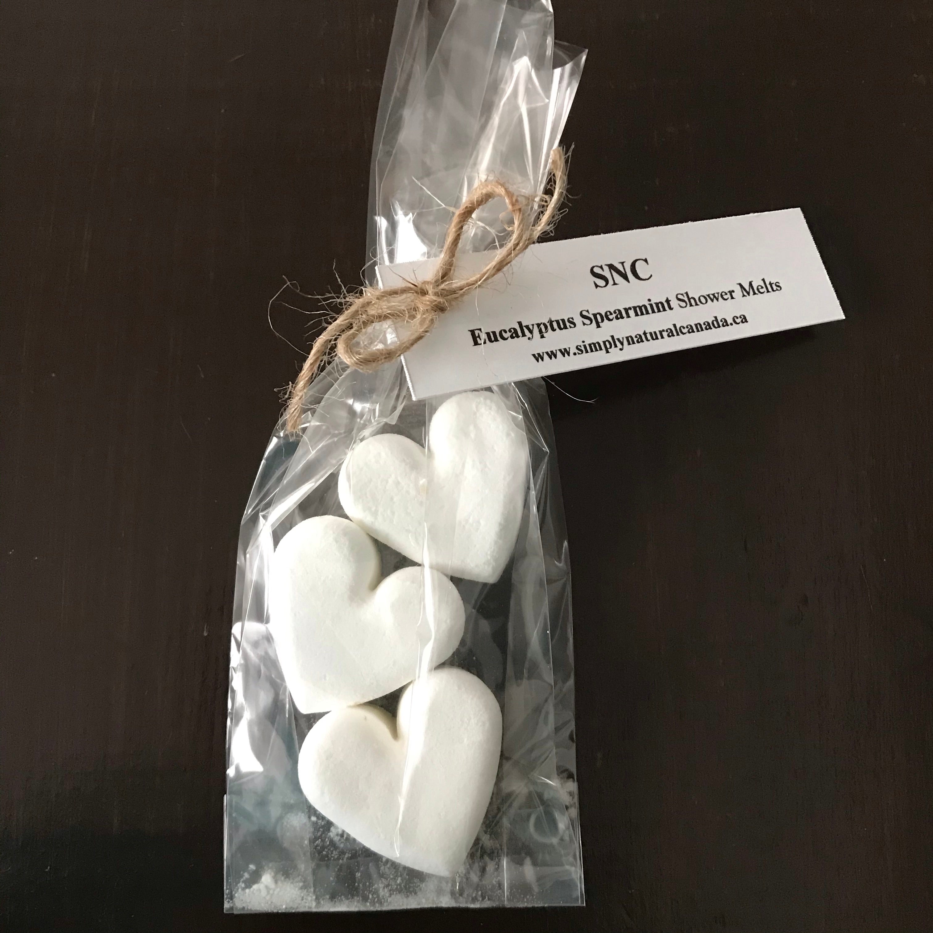 Close-up of handcrafted heart-shaped shower steamer melts with visible textured surface and delicate embossed design detail.