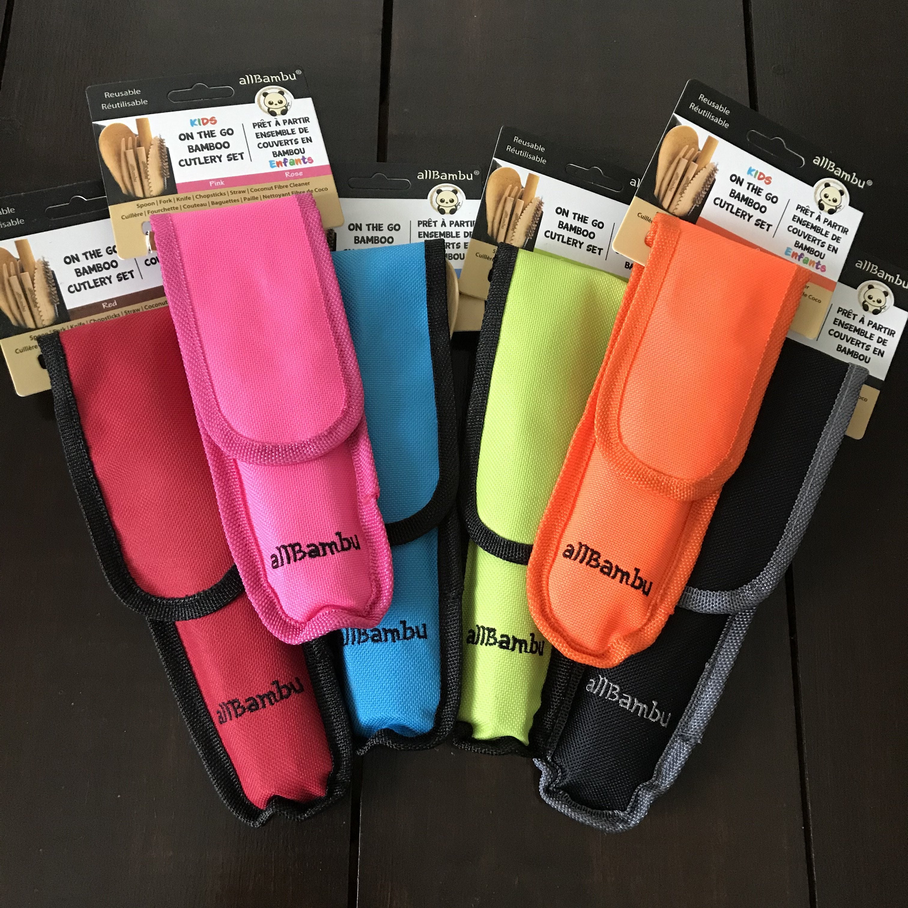 Close-up of bamboo handles and stainless steel tips on the travel cutlery set arranged on a wooden table.