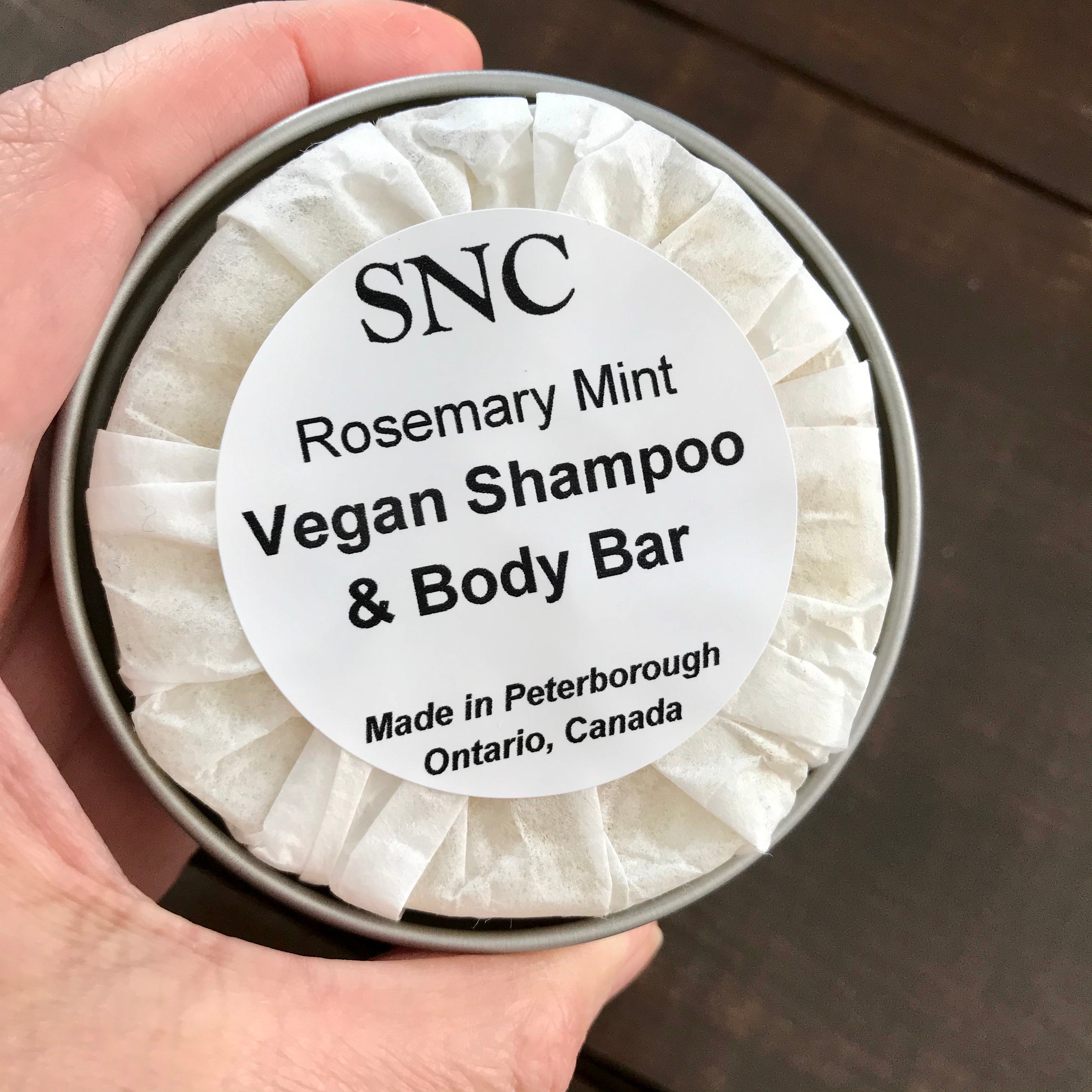 Close-up of the shallow tin's lid showcasing clean labeling and textured surface for easy application handling