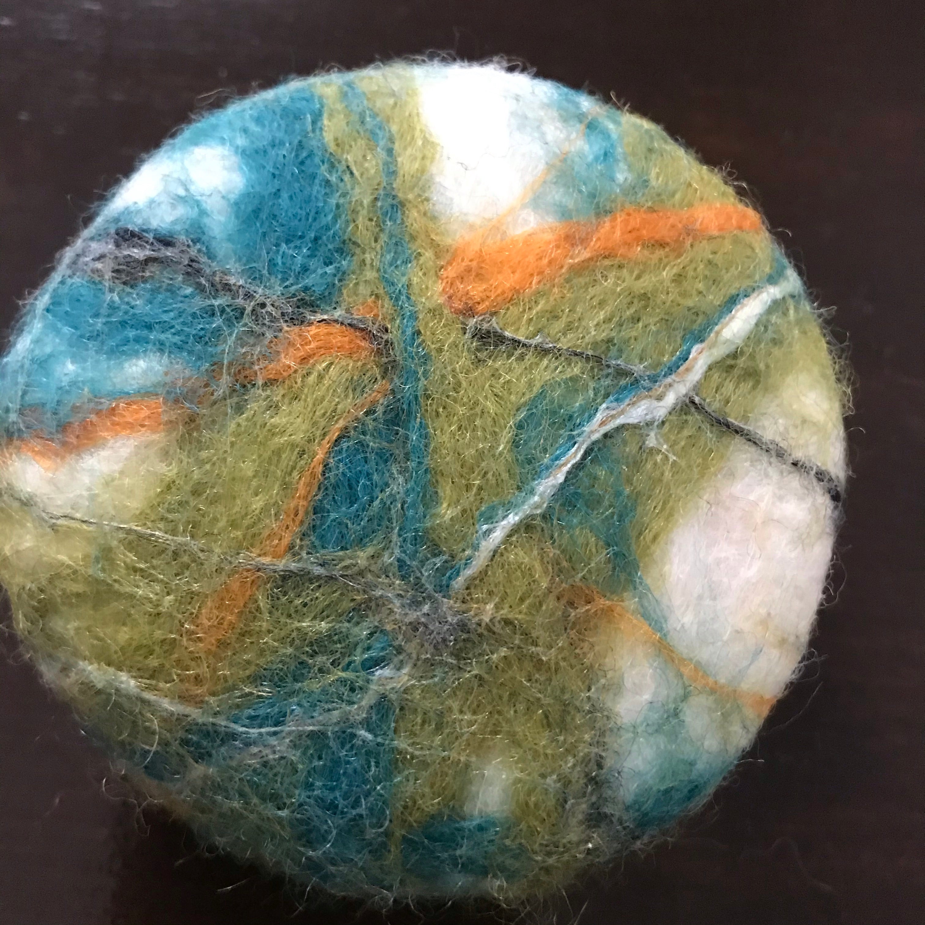 Close-up of felted cedar sage soap’s textured surface highlighting natural fibers and intricate felting details from an