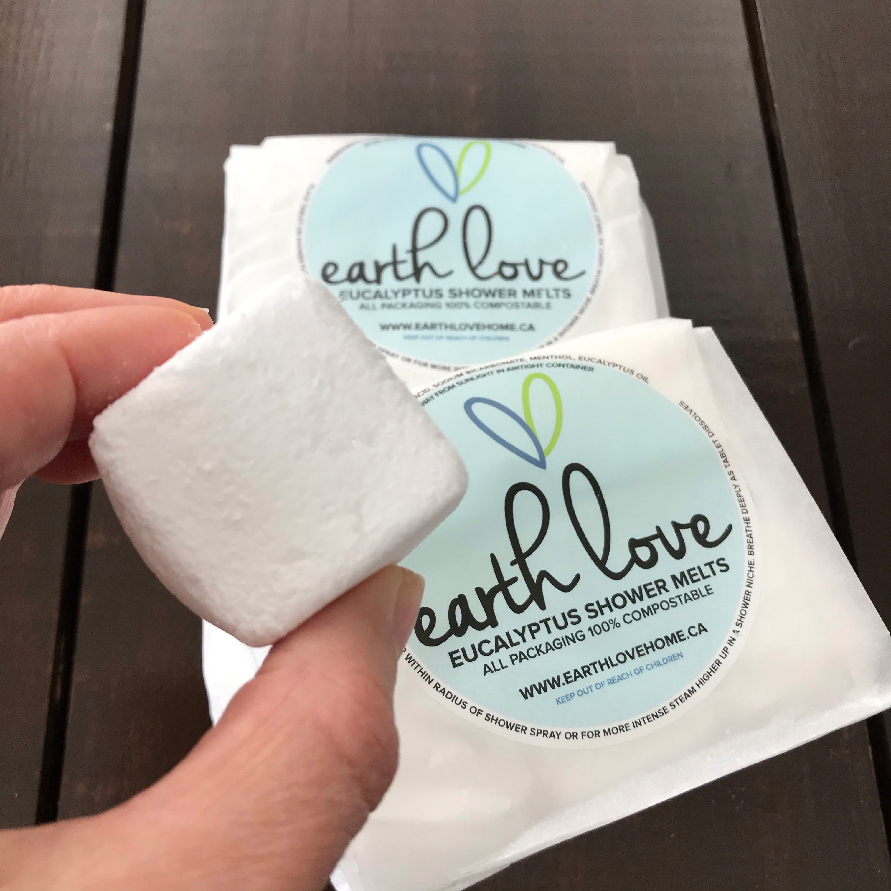Earth Love Eucalyptus Shower Melts in biodegradable packaging, with natural green and white spheres emitting fresh, herbal