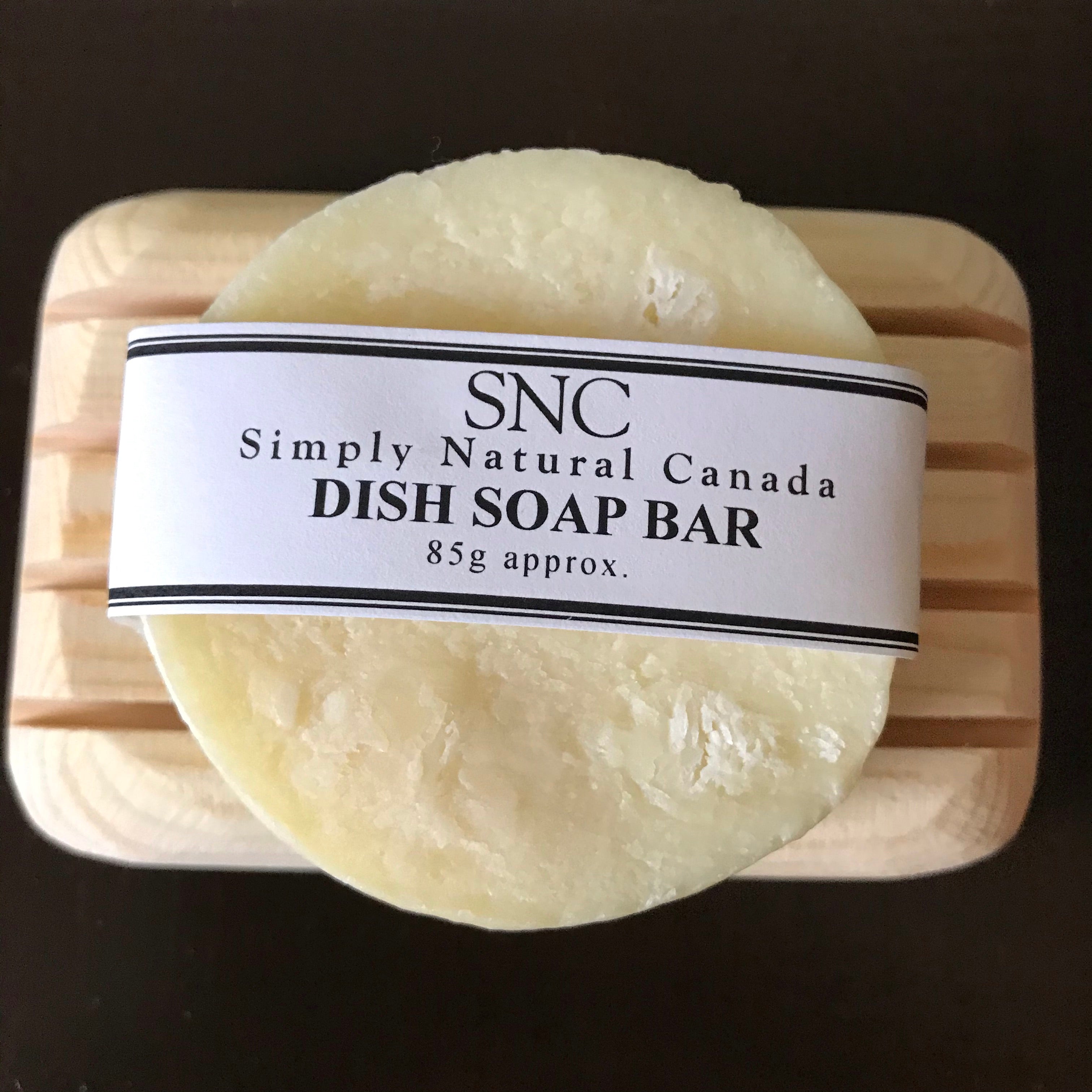 Close-up of the textured, oval-shaped dish soap bar with visible natural ingredients and rough, plant-based surface detail.