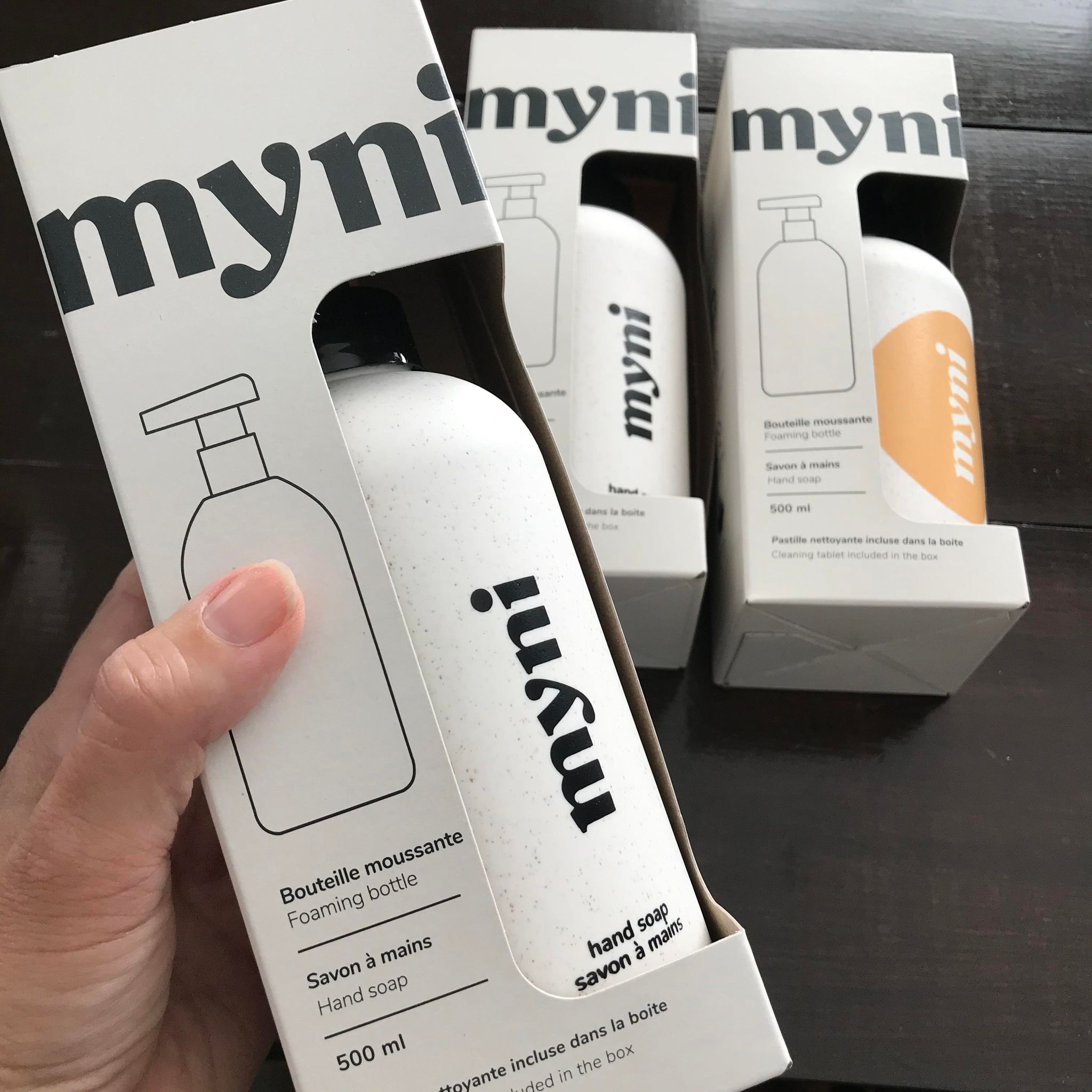 Close-up of Myni Foaming Hand Soap Kit label and soft matte white dispenser finish from a front slightly angled perspective.