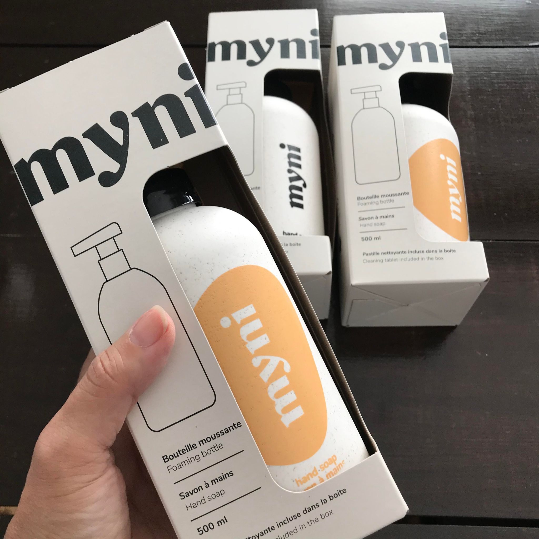 Close-up of the Myni Foaming Hand Soap Kit label showing product name and sleek black finish on the dispenserâ€™s textured