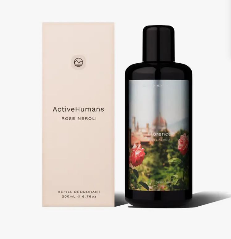 Close-up of the clear spray nozzle and light pink rose neroli scent label on the Active Humans deodorant bottle from a