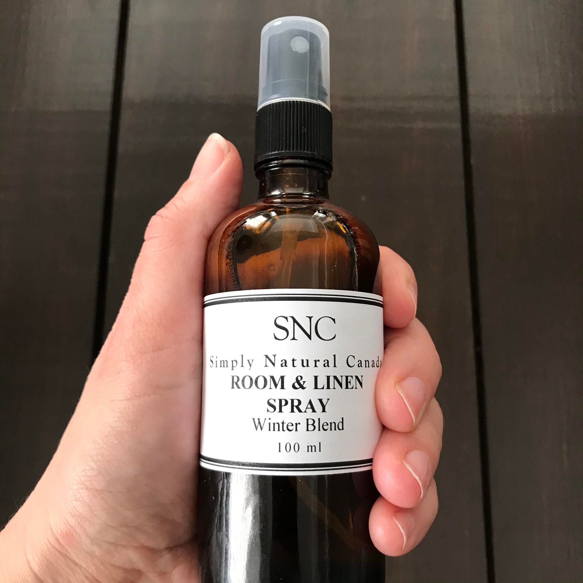 Close-up of lavender-infused linen spray bottle with textured label and frosted glass finish, highlighting aromatic