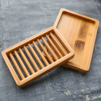 Close-up of the dual-layer bamboo soap dish showing smooth surface texture and drainage holes from a top-down angle.